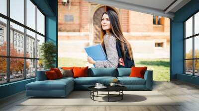 American university student smiling with coffee and book bag on campus Wall mural